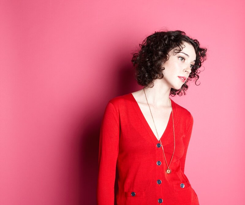 woman in red dress against pink wall