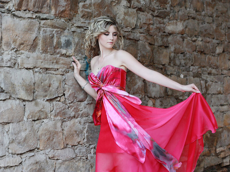 Woman in red dress against stone wall