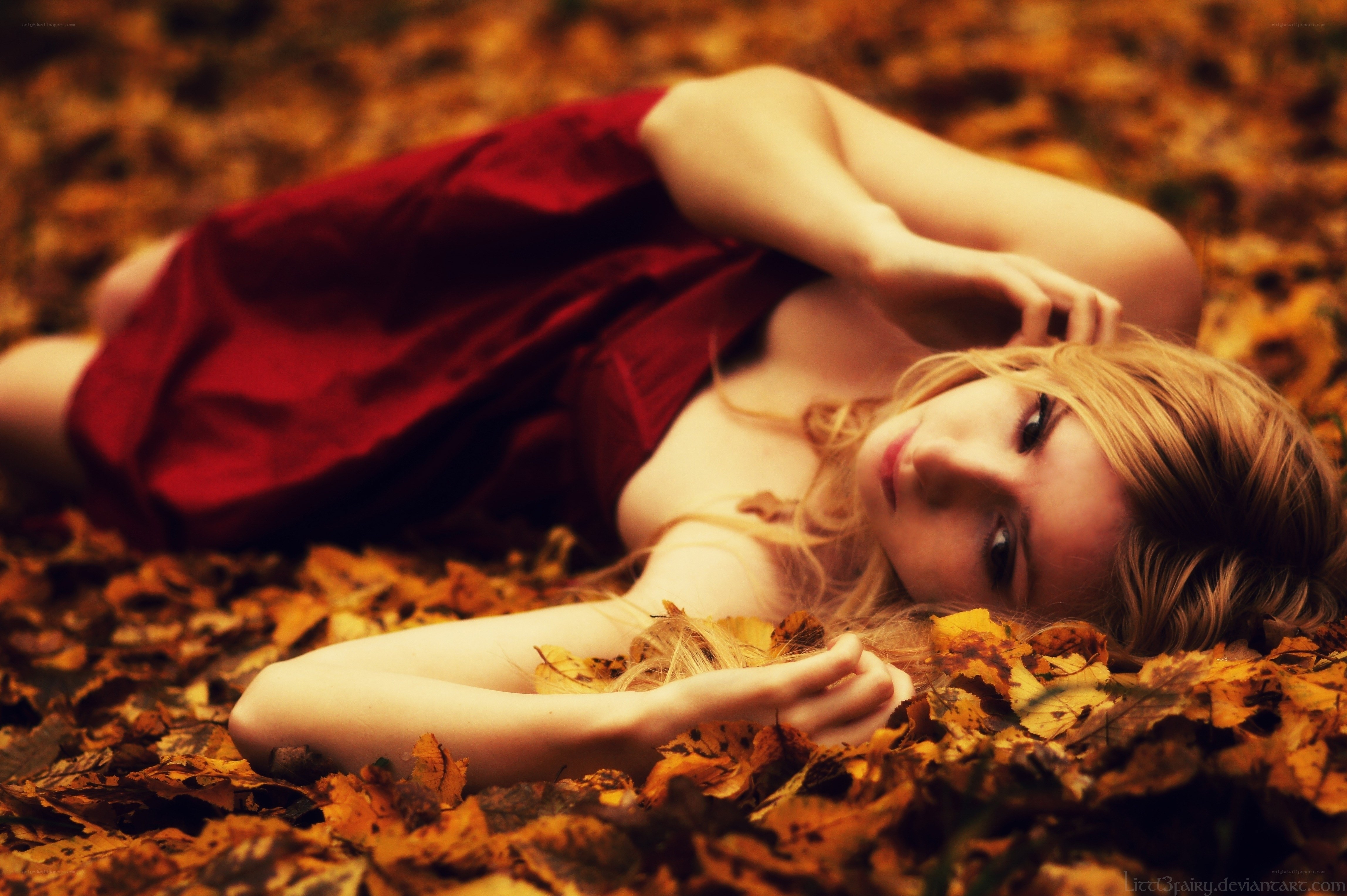 woman in red dress among autumn leaves