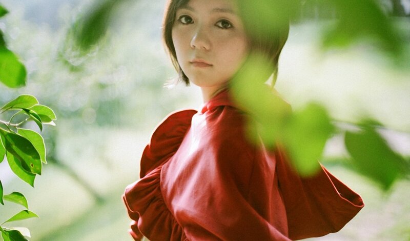 woman in red dress among green leaves