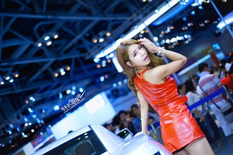 Woman in red dress at auto show