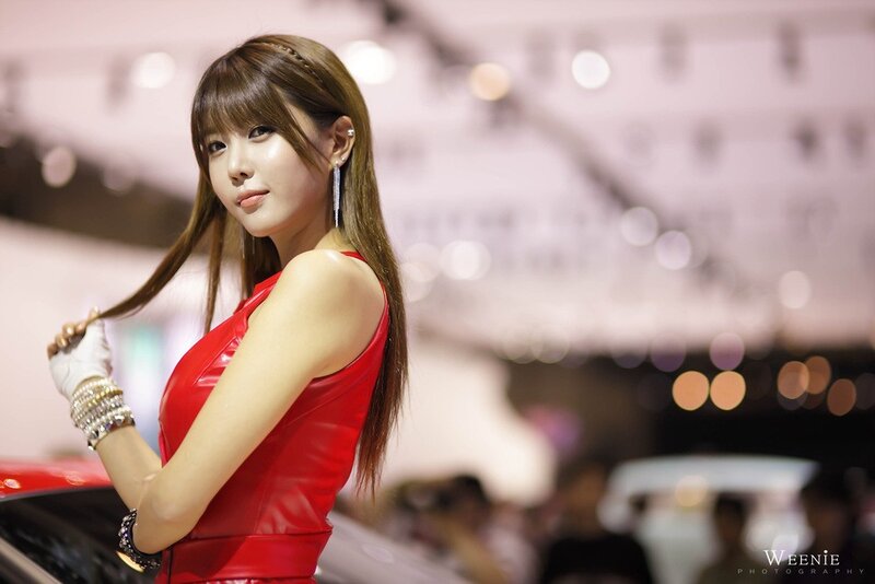 Woman in red dress at auto show