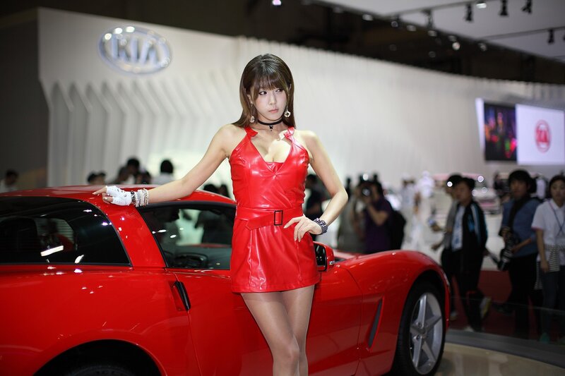 Woman in red dress at car show