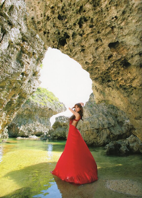 Woman in red dress at sea cave