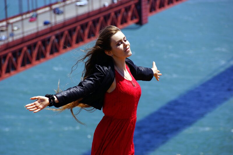 Woman in red dress by bridge