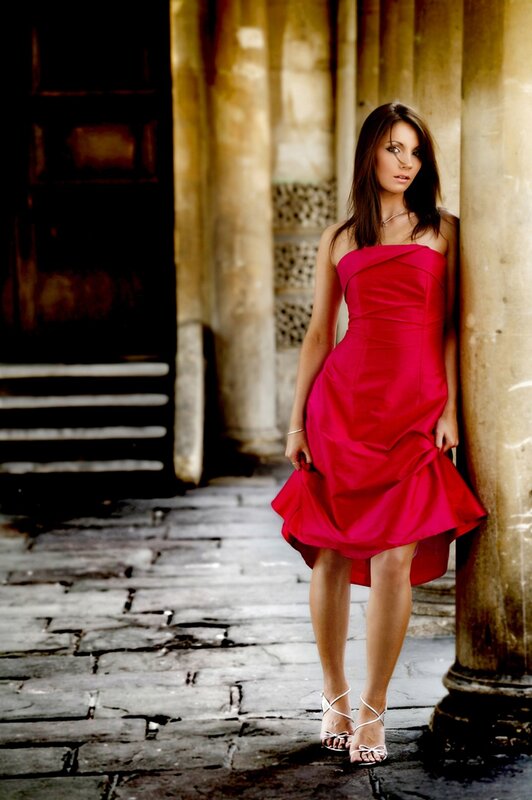 Woman in red dress by column