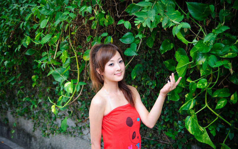 woman in red dress by green vines