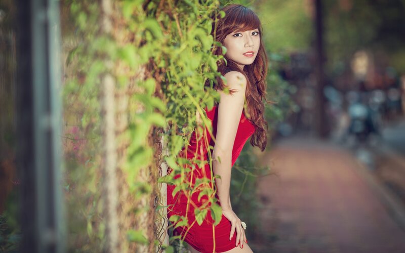 woman in red dress by greenery
