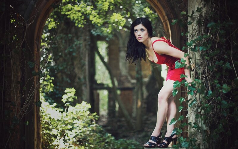 Woman in red dress by ivy arch