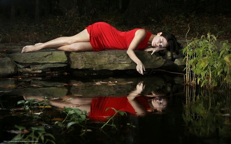Woman in red dress by pond