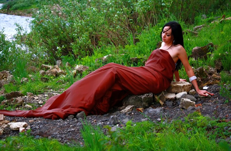 Woman in red dress by river