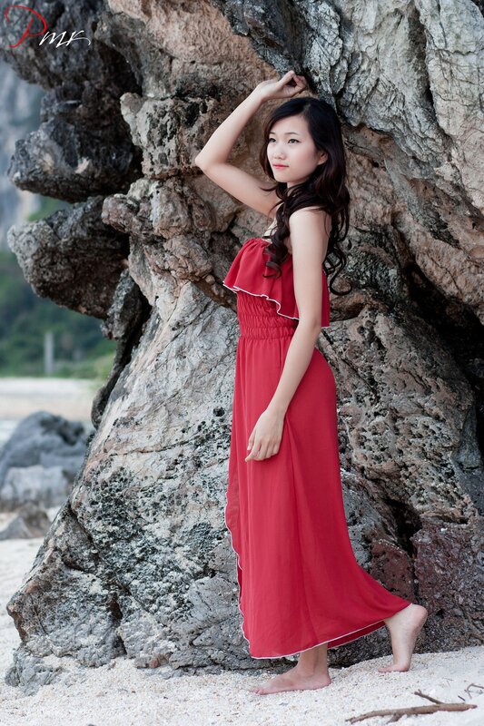 Woman in red dress by rocks