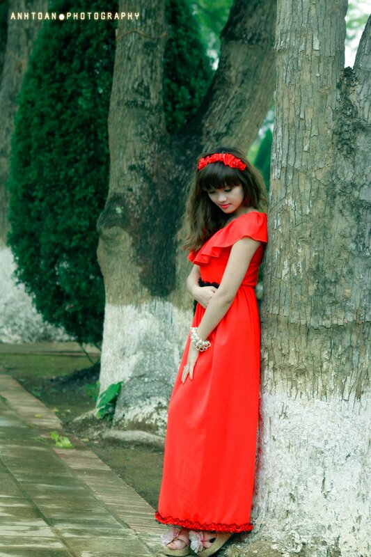 Woman in red dress by tree