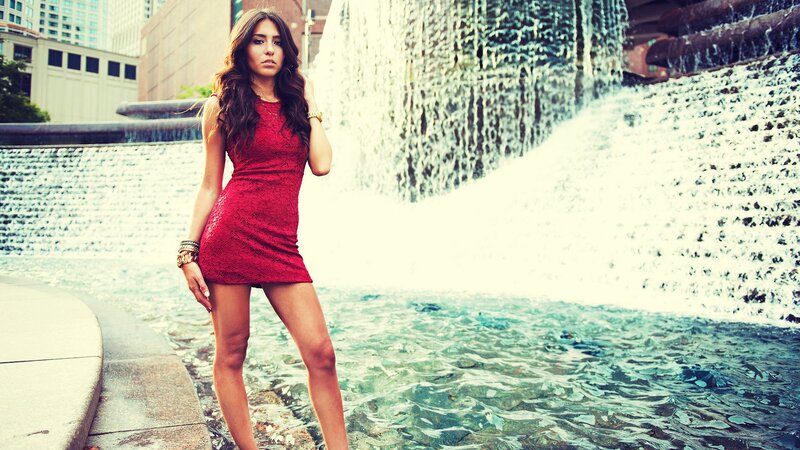 woman in red dress by waterfall