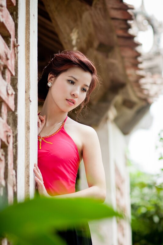 woman in red dress by window