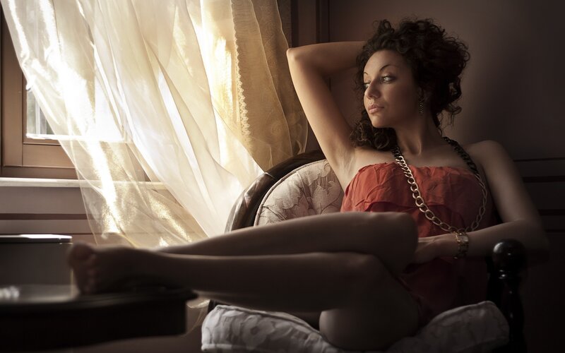 woman in red dress by window