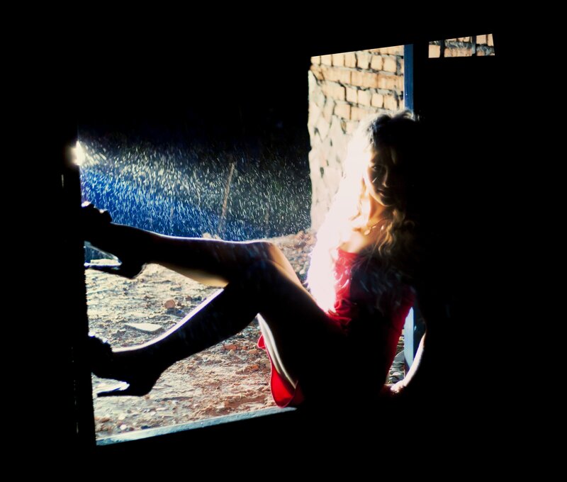 woman in red dress by window