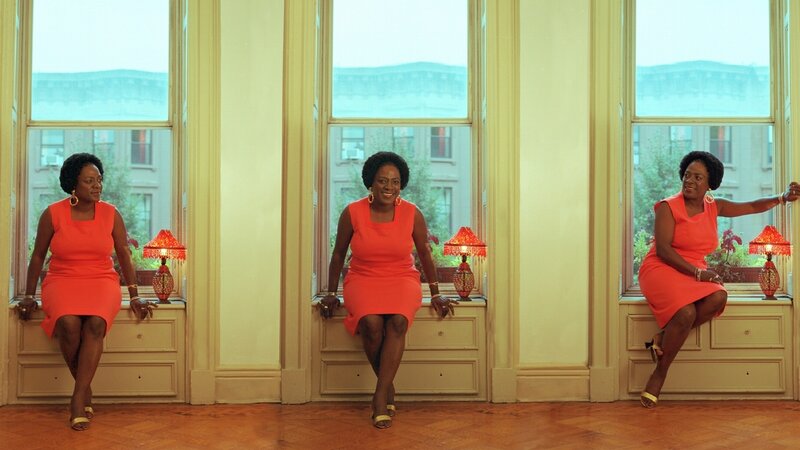 Woman in red dress by windows