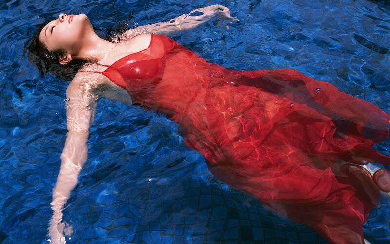 woman in red dress floating in pool