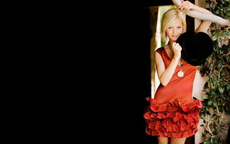 woman in red dress holding hat