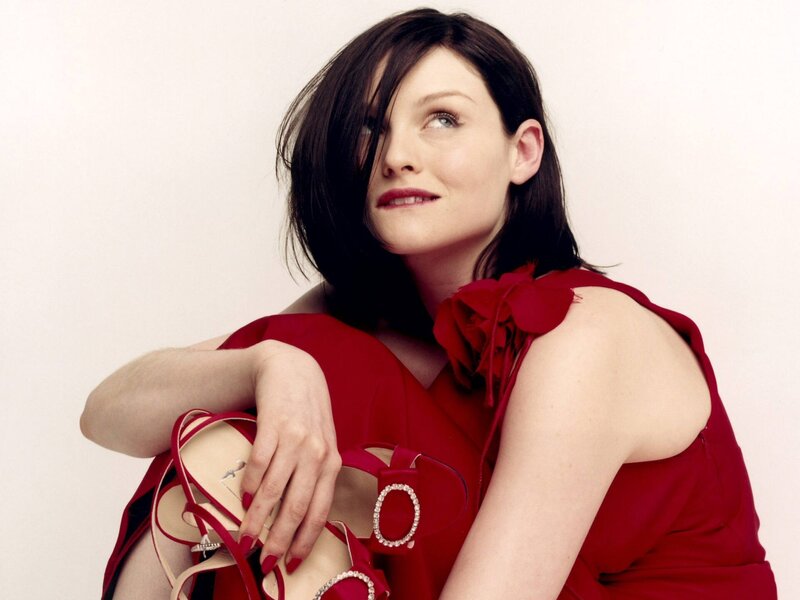 woman in red dress holding shoes