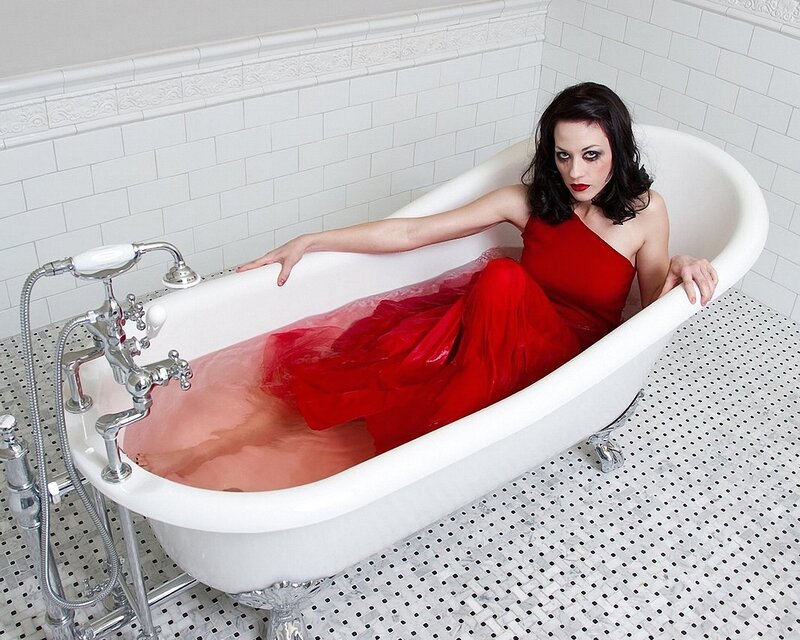 Woman in red dress in bathtub