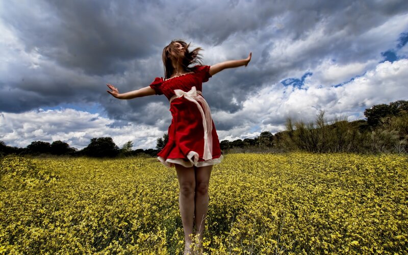Woman in red dress in yellow field