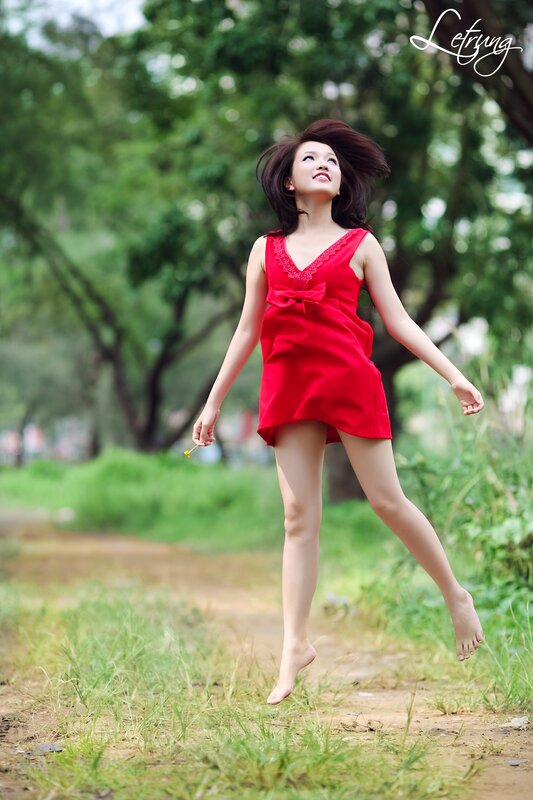 Woman in red dress jumping