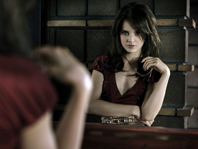 woman in red dress looking at mirror