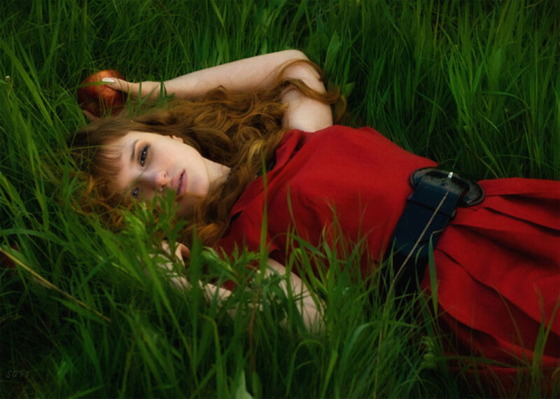 Woman in red dress lying in grass