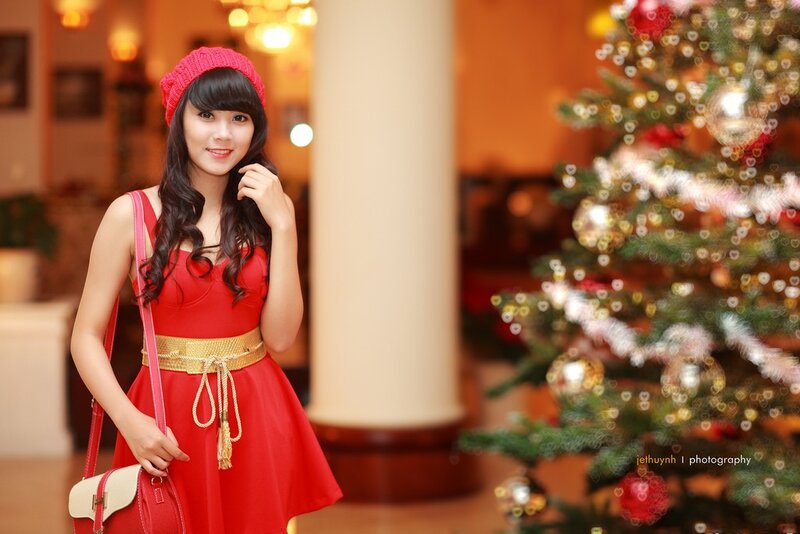 woman in red dress near christmas tree