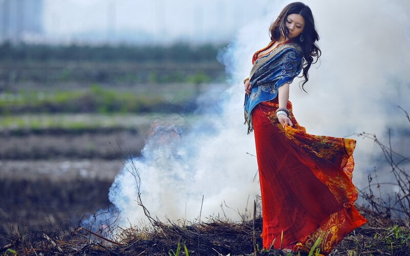 Woman in red dress near smoke
