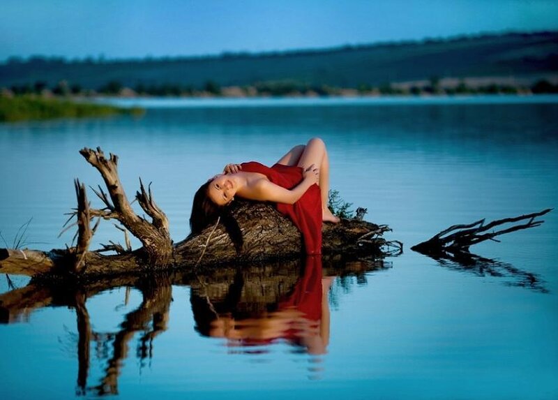Woman in red dress on driftwood