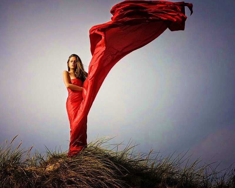 Woman in red dress on dune