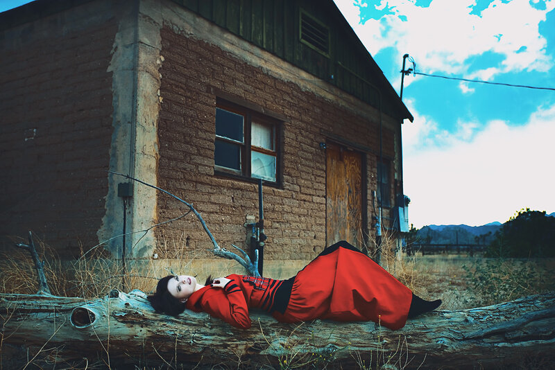 Woman in red dress on log