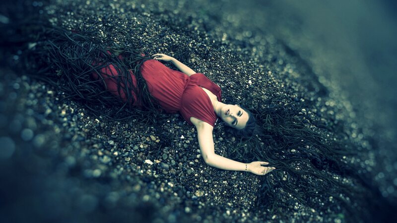 Woman in red dress on pebbles