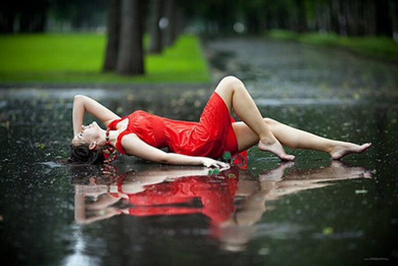 Woman in red dress on wet pavement