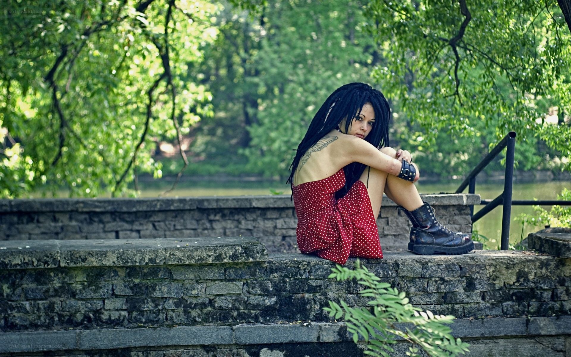 Woman in red dress sitting by water