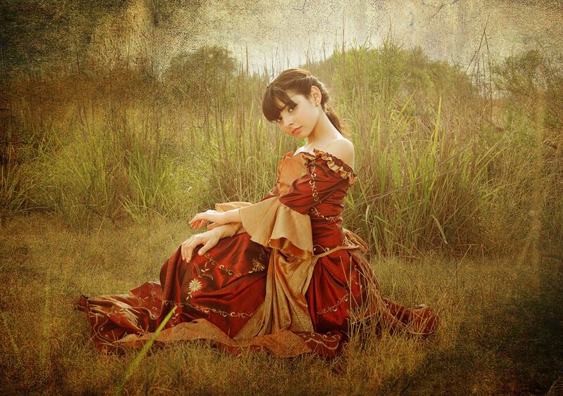 Woman in red dress sitting in field