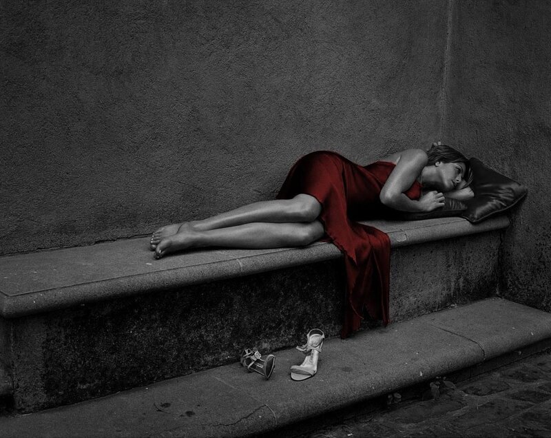 Woman in red dress sleeping on bench