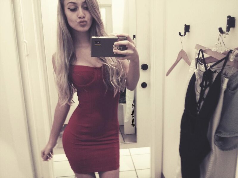 woman in red dress taking mirror selfie