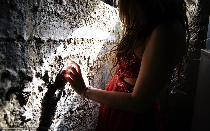 woman in red dress touching wall