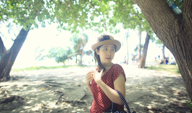 Woman in red dress under trees
