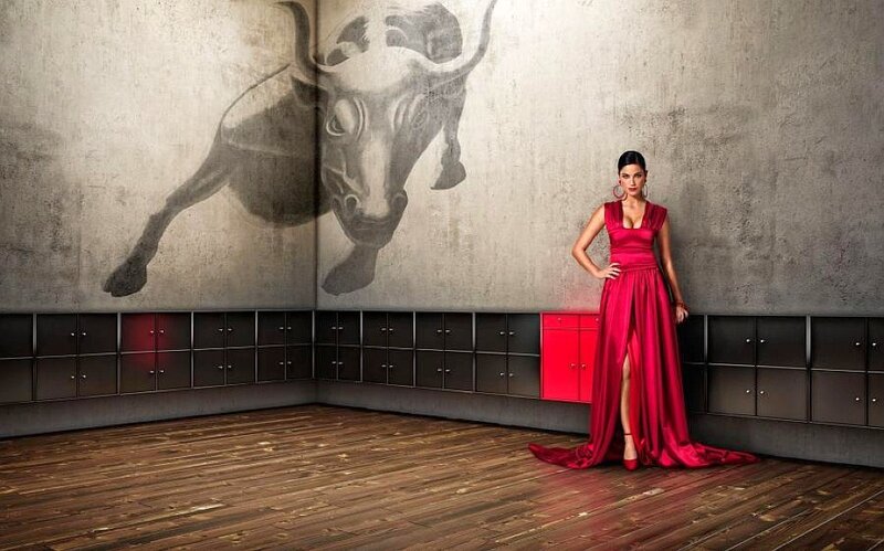 Woman in red dress with bull mural