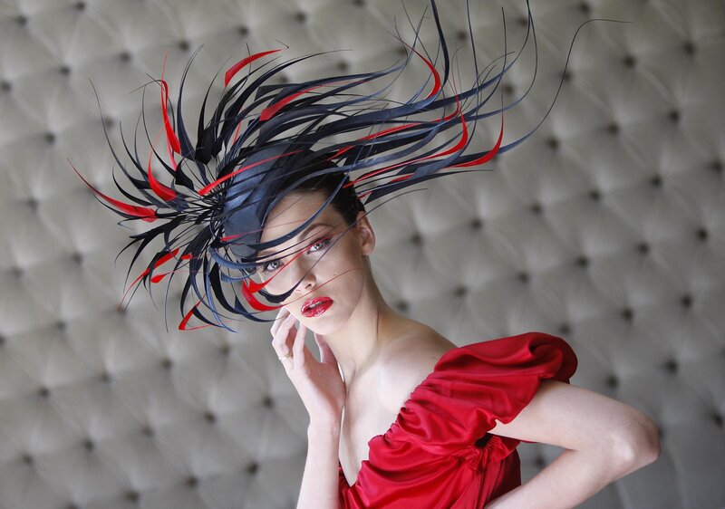 woman in red dress with feather hat