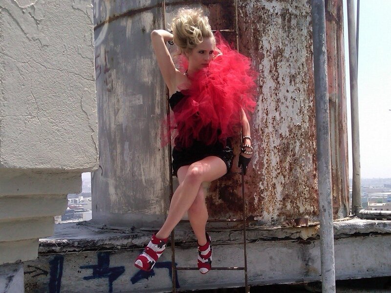 Woman in red feather boa on rooftop
