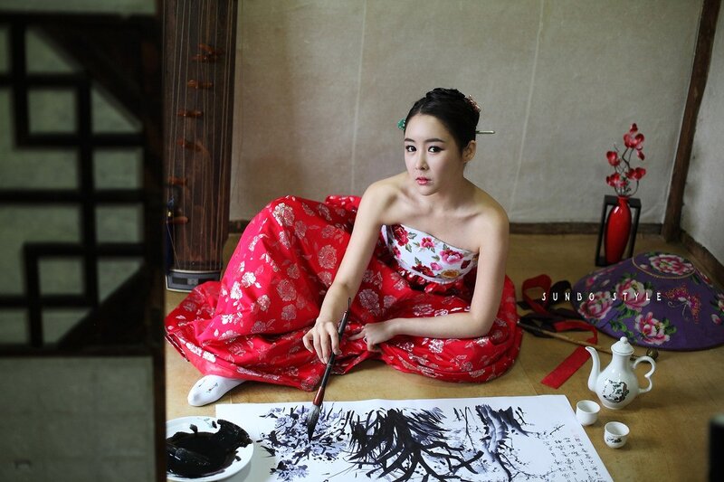 woman in red hanbok painting