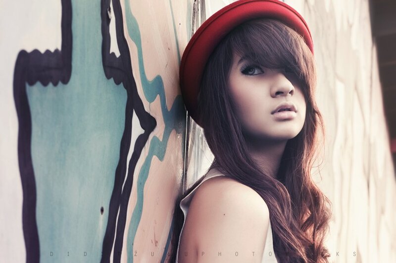 woman in red hat against graffiti wall