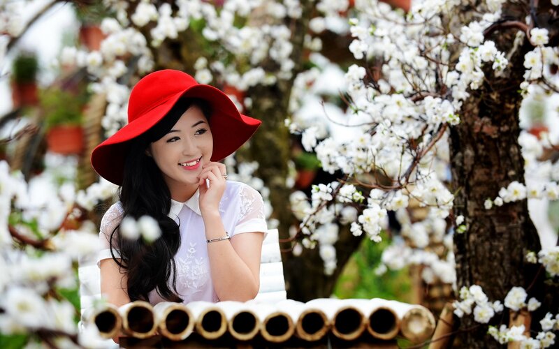 Woman in red hat among blossoms