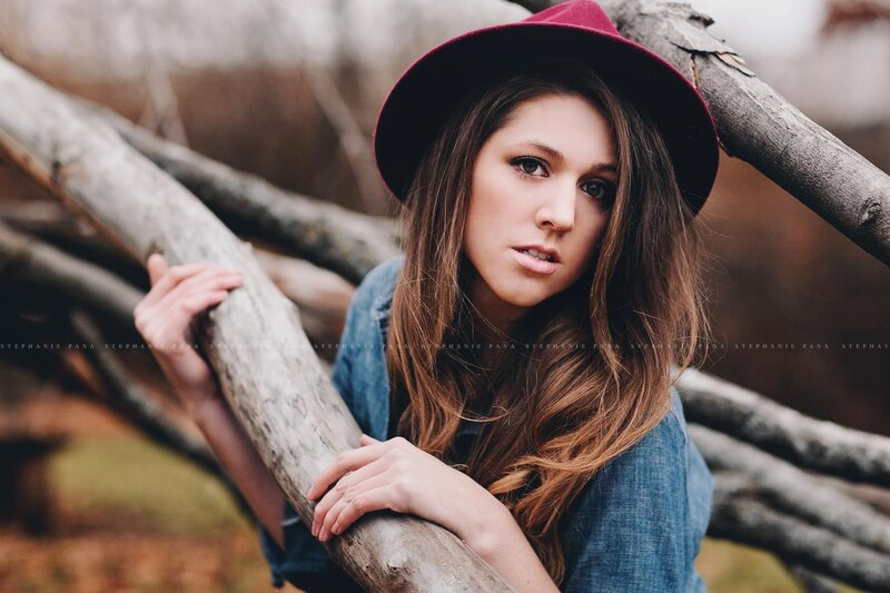 woman in red hat by logs